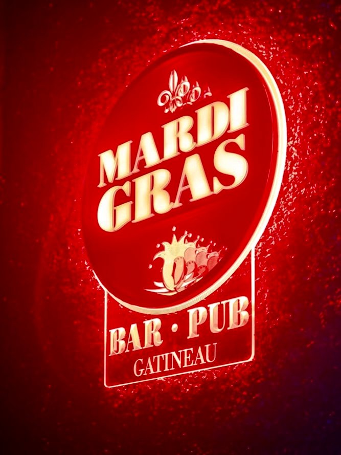 Glowing neon sign illuminating a bar in Gatineau at night.